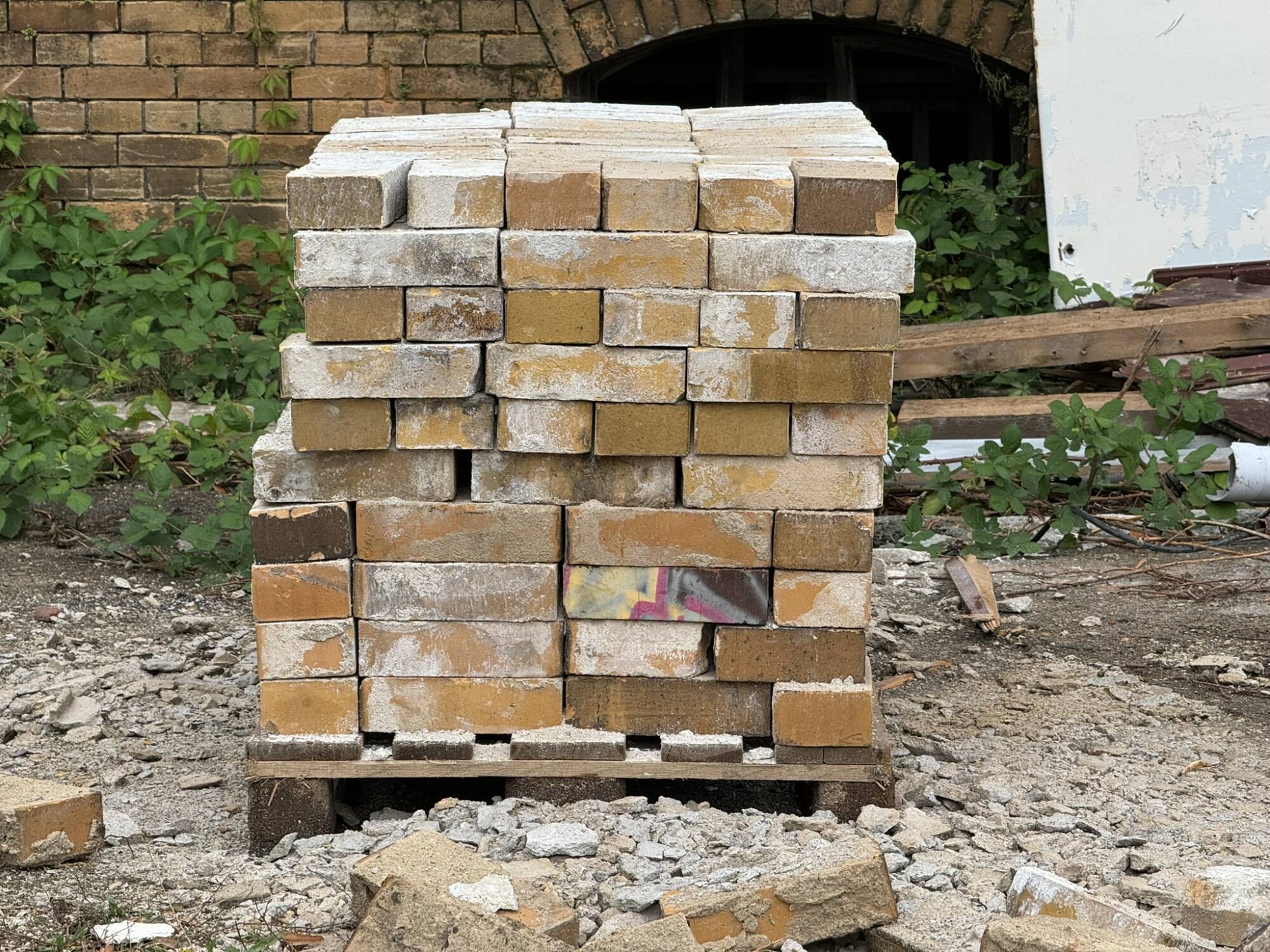 Palette mit sauber aufgestapeltem Klinker, welcher beim Abriss von Altbestandsgebäuden erhalten blieb und bei der Neubehauung wiederverwendet werden soll.